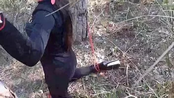 play Seksi bir kıyafetle bir ağaca bağlı, maskeli ve merhametsiz bir açık hava derin boğazı